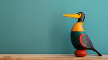 A colorful wooden cormorant toy stands on a desk photo