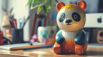A colorful wooden panda toy sits on a desk, surrounded by office supplies photo