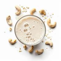 A glass of cashew milk with a creamy texture and a light dusting of oat flakes photo
