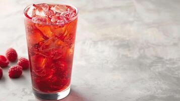 A glass of raspberry iced tea with ice cubes and fresh raspberries photo