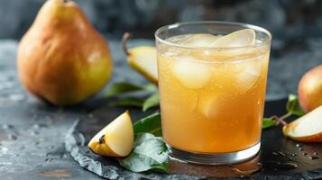 A glass of pear juice with ice cubes and pear slices, on a slate serving tray photo