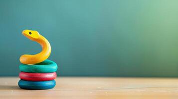 A wooden snake toy sits on a desk, resting on colorful rings photo