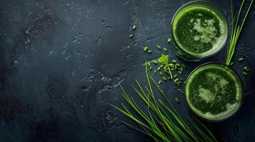 Two glasses of wheatgrass juice with fresh herbs on a dark background photo