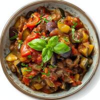 Ratatouille with fresh basil in a rustic bowl photo