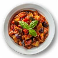 A close-up shot of a bowl of ratatouille with basil garnish photo