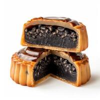 Two mooncakes with black sesame filling, cut open to reveal the deliciousness inside photo
