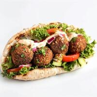 Falafel pita pocket with creamy sauce, lettuce, and tomato photo