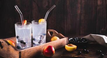Refreshing lemonade with blackcurrant, nectarine and ice in glasses on the table web banner photo