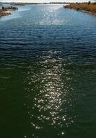 Reflection of the sun and glare in the water of the Tiligul estuary canal, Ukraine photo