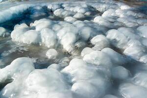 Smooth blocks of melting ice glisten in the sun, ice near the Black Sea, Odessa photo