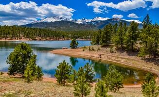 Panorama Snow-capped and forested mountains near a mountain lake, Pikes Peak Mountains in Colorado Spring, Colorado, US photo