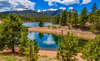 panorama nevadas y boscoso montañas cerca un montaña lago, lucios pico montañas en Colorado primavera, Colorado, nosotros foto