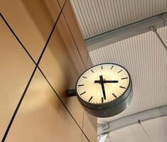 Round analog clock with no number isolated on horizontal train station wall and ceiling background. photo