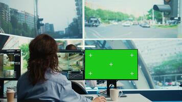 Agency employee works with greenscreen display and monitoring traffic, using city surveillance footage via satellite radar and CCTV system. Young woman following sensors. Camera B. photo