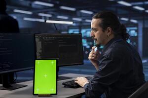 Technician using isolated screen screen tablet to check for signs of imminent failure in data center. IT expert working on mockup device to prevent damages in server farm, monitoring critical systems photo
