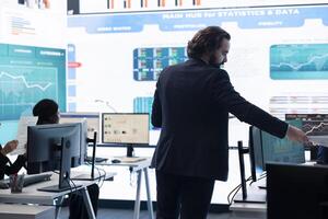 Forecast affiliates working in coworking space office to review latest business news based on performance metrics and progress. Consultants fight to expand the enterprise globally. photo