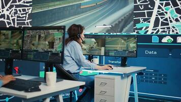 Frustrated tired employee failing to help the couriers with order shipment directions, feeling stressed and overworked in control center. Satellite map gps and CCTV footage. Camera B. photo