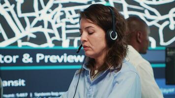 Call center employee communicating alternative routes for couriers, trying to avoid traffic by using satellite city map and surveillance CCTV footage. Operator gives gps directions. Camera A. photo