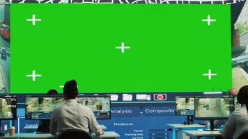 Shipping agency workers examine satellite map with huge greenscreen display, monitoring parcels and orders for clients. Employees using surveillance CCTV footage to get updates. Camera A. photo