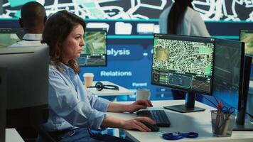 Employee navigating on satellite radar and map to search for routes, helping courier to avoid traffic and successfully deliver orders. Operator in monitoring room using gps coordinates. Camera A. photo