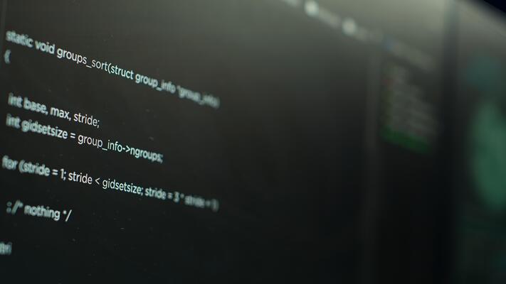 Extreme close up shot of lines of code displayed on computer monitors used by cybercriminal stealing sensitive information. Virus scripts running on PC infecting network systems, breaking passwords