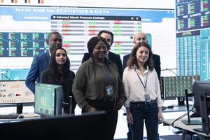 Diverse group of business professionals posing together in monitoring room, multinational company headquarters. Executive management team working with big data screen in the office. photo