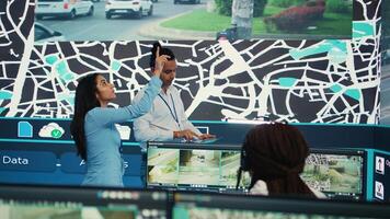 Indian supervisors examining traffic routes on satellite map, gathering data on surveillance CCTV system to ensure express delivery. Employees tracing and locating trucks with gps network. Camera B. photo