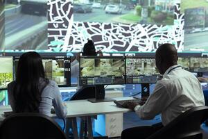 Team tracking a delivery car by using satellite navigation in agency control center, help couriers navigating around the city and avoid traffic to deliver orders in time. Surveillance CCTV footage. photo