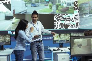 Indian operators consulting on alternative routes gps locating in control center, employees operating with CCTV footage to guide couriers in traffic. Operators follow satellite navigation. photo