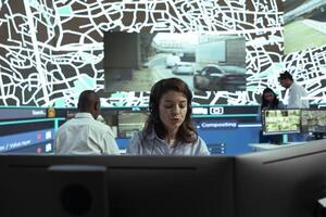 Agency dispatcher communicates cargo gps coordinates to clients, handling any order delay complains at call center department. Employee monitoring couriers stuck in heavy traffic. photo