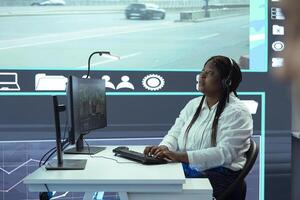 African american dispatch operator monitoring traffic activity on CCTV system surveillance footage, license plate reading and registering in the government database. High tech public security. photo