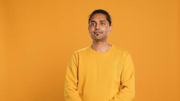 Portrait of radiant optimistic indian man with positive facial expression smiling, looking pleased. Calm merry person crossing arms, feeling satisfied, studio backdrop, camera A photo