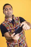 Man entertained by playing videogames on smartphone in landscape mode, enjoying leisure time. Person enjoying games on phone, competing against other players, isolated over studio background photo