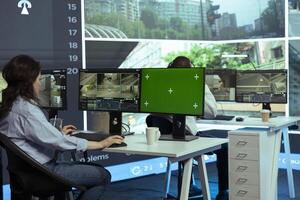 Operator monitors traffic next to an isolated mockup display, following real time surveillance footage from radar cameras system. Agency employee works with city CCTV intelligence. photo