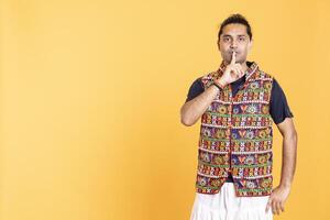 Annoyed man doing shushing hand gesturing, irritated by noise, having negative mood. Person placing finger on lips, doing quiet sign gesture, isolated over studio background photo