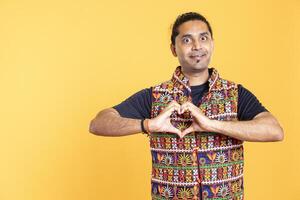Portrait of jolly friendly man doing heart symbol shape gesture with hands. Cheerful nurturing person showing love gesturing, being appreciative, isolated over studio background photo