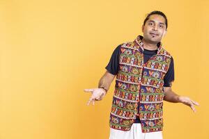 Portrait of upbeat man wavering, oscillating between answers, shrugging shoulders. Radiant person doing questioning hand gesturing, hesitating to provide response, isolated over studio background photo