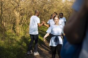 Male environmentalist sharing a high five with all of his team, enjoying successful mission to protect the natural ecosystem. African american activist being happy with a job well done. photo