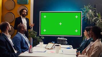 Sales management team working with isolated copyspace display in a briefing meeting, sharing ideas and practices to improve workflow. Organization affiliates gathered in a conference. Camera B. photo