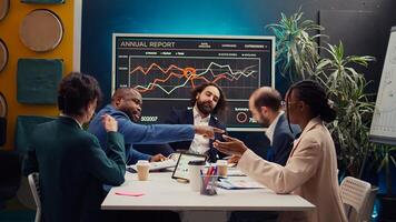 Public relations department working to improve the organization social media presence, attend an executive meeting. Studying trends and making decisions to corelate with company objectives. Camera B. photo