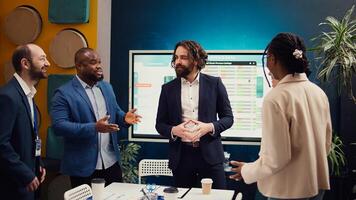 Team of startup employees gathering for a briefing session in boardroom, developing strategies to improve corporate culture and personnel engagement in multiple projects. Camera B. photo