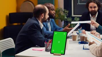 Chief information officer attends meeting with staff members next to isolated screen, discussing latest company achievements and success metrics. Business people share project updates. Camera A. photo