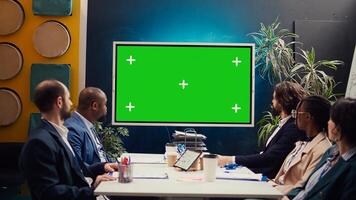 Startup team watching an ad campaign on greenscreen display, examining the final promotional product to ensure sales growth. PR specialists collaborating on enterprise development. Camera B. photo
