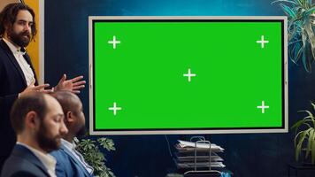 Sales management team working with isolated copyspace display in a briefing meeting, sharing ideas and practices to improve workflow. Organization affiliates gathered in a conference. Camera A. photo
