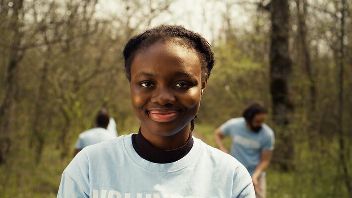 African american girl presenting small sprout with organic soil ready for planting in the ground, preserving nature and forest habitat. Young activist doing voluntary work to grow trees. Camera B.