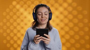 Voice actor smiling while reading ebook, portraying proud and sassy character, studio background. Woman reenacting digital novel, interpreting cheerful protagonist, reading text from tablet, camera B photo