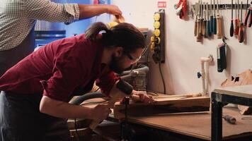Woodworker using bench vise to hold lumber block, carving intricate designs into wood using chisel and hammer. Craftsperson using vice tool to clamp piece of wood, shaping log with tools, camera A photo