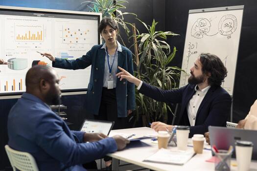 Team colleagues examining sales infographics on interactive presentation, reviewing annual reports to understand what needs to change in order to expand the enterprise internationally. photo