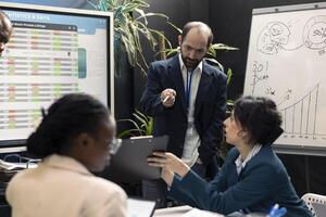 Chairman of the board reviews potential enterprise expansion, team supervisor and the members look into data visualizations. Forecast affiliates seek to boost organizational earnings. photo