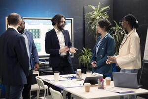 Group of corporate employees are meeting in a boardroom office, debating possible business deals or global collaborations. Coworkers starting a briefing session to share visions and ideas. photo